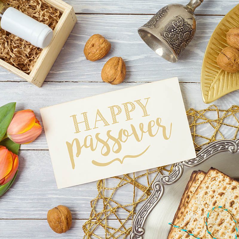 Jewish holiday Passover greeting card with matzo, seder plate, w Jewish holiday Passover greeting card with matzo, seder plate, wine and tulip flowers on wooden table